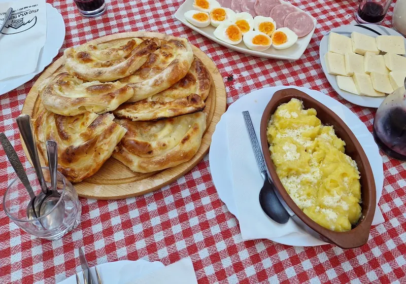 Homemade pie, eggs, cheese, cream and fresh milk on a gingham-covered table