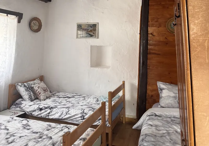 A guest room under dark wooden beams with fresh white bedding